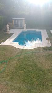 a swimming pool with a hose in a yard at Rincón Spa Seule in Ciudad Lujan de Cuyo