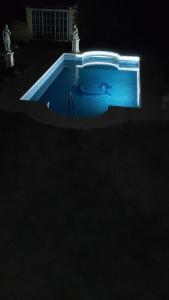 a swimming pool lit up in the dark at night at Rincón Spa Seule in Ciudad Lujan de Cuyo