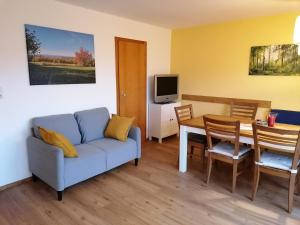 a living room with a couch and a table at Ferienwohnung Zum Kirschhof in Hofbieber