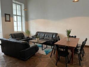 a living room with black leather furniture and a table at Geräumige Altbauwohnung im Zentrum in Graz