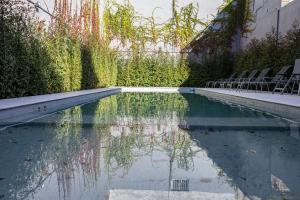 una piscina con sedie, alberi e acqua di Departamentos en San Telmo 360 a Buenos Aires