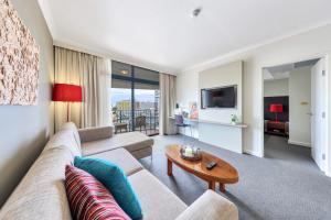 ein Wohnzimmer mit einem Sofa und einem Tisch in der Unterkunft Resort Style Escape King Bed Pool Balcony in Darwin