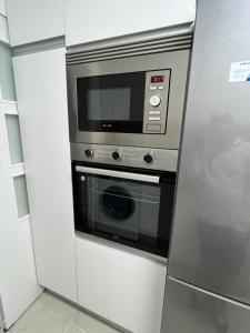 La cocina está equipada con microondas y nevera. en Apartamento en Zaragoza con parking, en Zaragoza