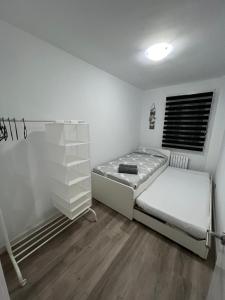 a white bedroom with a bed and a window at Apartamento en Zaragoza con parking in Zaragoza