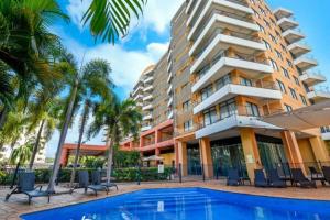 een hotel met een zwembad voor een gebouw bij Resort Style City View King Bed Pool Balcony in Darwin