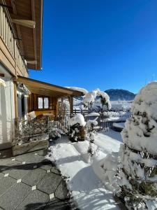 a house covered in snow with a tree at Ferienwohnung Oswald in Unterammergau