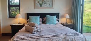 a bedroom with a large bed with towels on it at Sunset place, Cathkin Estate in Ardmore