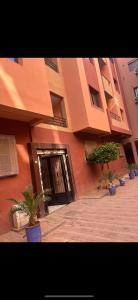 un edificio con una puerta y macetas delante de ella en Superbe Appartement proche centre marrakech, neuf tout équipé, en Marrakech