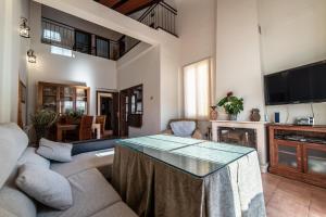 uma sala de estar com um sofá e uma mesa em Casa El Oasis del Lago Alojamiento Rural em Córdoba