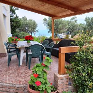a patio with a table and chairs and flowers at Andi in Stalettì