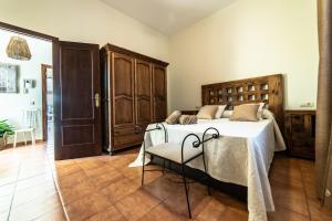 a bedroom with a bed and a wooden headboard at Casa El Oasis del Lago Alojamiento Rural in Córdoba