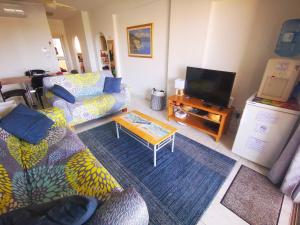 ein Wohnzimmer mit 2 Sofas und einem TV in der Unterkunft 103 Regina Gardens in Paphos City