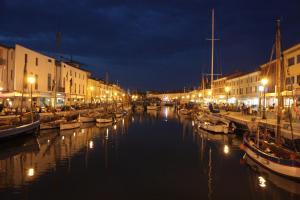 a group of boats docked in a canal at night at Zaffiro Blu in Bellaria-Igea Marina