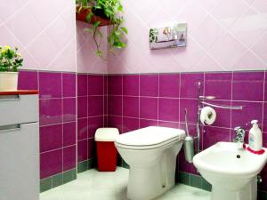 a purple bathroom with a toilet and a sink at Zaffiro Blu in Bellaria-Igea Marina