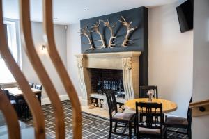 a dining room with a fireplace and a table and chairs at The Greenhead Hotel in Greenhead