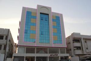 un edificio alto con ventanas coloridas en una ciudad en جوان سويت للشقق المخدومة en Yeda