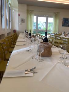a long table with wine bottles and glasses on it at San Giuseppe Casa per Ferie in Quercianella