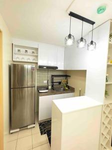 a kitchen with a stainless steel refrigerator and white cabinets at Condo For Rent in Ortigas (KIMEA Deluxe) in Manila