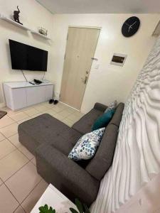 a living room with a couch and a flat screen tv at Condo For Rent in Ortigas (KIMEA Deluxe) in Manila