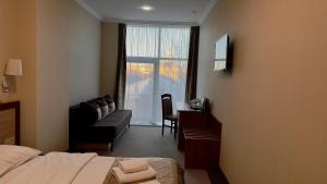 a hotel room with a bed and a desk and a window at Civilization in Dnipro