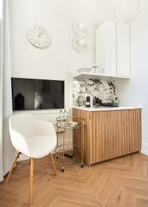 kuchnia z białym krzesłem i stołem w obiekcie WILCZA Abdank City Center Studio w Warszawie