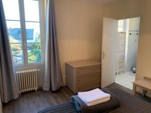 サン・マロにあるRésidence Le Rochebonneの小さな客室で、ドレッサーと窓が備わります。