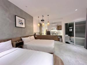 a hotel room with two beds and a bathroom at Kin Wander Tân Phong, The Moonage in Ho Chi Minh City