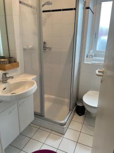 ein Badezimmer mit Dusche, Waschbecken und Toilette in der Unterkunft Rosenhus 5 in Horumersiel