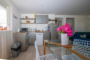 a kitchen with a vase of flowers on a glass table at ILET TURQUOISE in Le Gosier