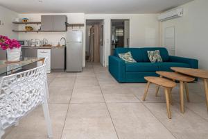a living room with a blue couch and a table at ILET TURQUOISE in Le Gosier