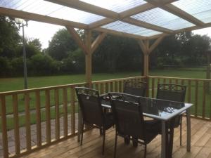 a patio with a table and chairs on a deck at Stacaravan op camping De Peelweide in Grashoek