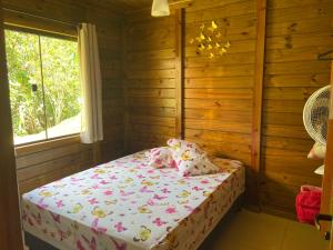 1 dormitorio con 1 cama en una habitación de madera en Recanto da Tia Juju, en Santa Teresa