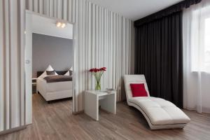 a room with a mirror and a chair and a bed at Hotel Asahi in Düsseldorf