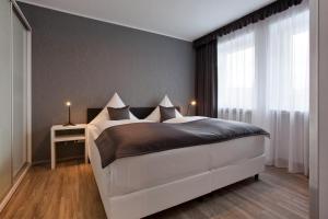 a bedroom with a large white bed and a window at Hotel Asahi in Düsseldorf