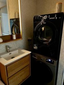 uma casa de banho com uma máquina de lavar roupa ao lado de um lavatório em Family appartement near 2024 Arena & Olympics em Issy-les-Moulineaux