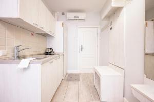 a white kitchen with white cabinets and a sink at Art Hotel in Druskininkai