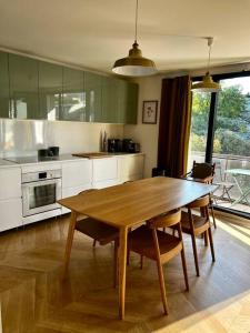 uma cozinha com uma mesa de madeira e cadeiras em Family appartement near 2024 Arena & Olympics em Issy-les-Moulineaux
