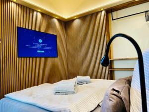 a room with a bed with a tv on the wall at HafenCity-Loft Stralsund in Stralsund