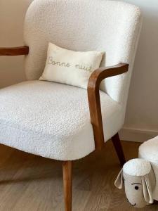 uma cadeira com uma almofada que diz venha nozes em Family appartement near 2024 Arena & Olympics em Issy-les-Moulineaux