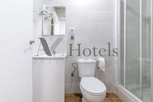 uma casa de banho branca com um WC e um chuveiro em AYZ Luis Cabrera-Auto check-in property em Madri