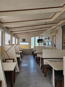 un comedor con mesas y bancos de madera en Hotel Sirio, en Rotonda