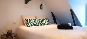 une chambre avec un lit avec deux oreillers dessus dans l'établissement Bulle de douceur en hypercentre, à Quimper