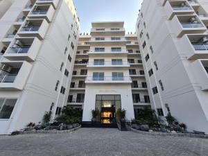 a building with two large white buildings at 1 Bed Modern Apartment, Pool, Gym, Cinema in Lahore