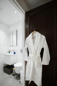 a white robe hanging on a door in a bathroom at Elegant central London flat - ideal for weekend city break in London