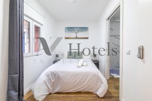 a white bedroom with a white bed and a window at AYZ Luis Cabrera-Auto check-in property in Madrid