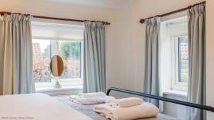 a bedroom with a bed with two towels on it at Picturesque Stone Cottage in the Heart of North Yorkshire Village in York