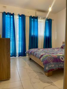 - une chambre avec des rideaux bleus et un lit dans l'établissement 2 Bedroom apartment close to the beach, à San Pawl il-Baħar