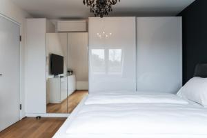 een slaapkamer met een groot wit bed en een televisie bij Modern stylish design apartment with free parking Emily in Wenen