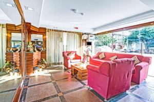 a living room with two red chairs and a table at The Royal Galaxy - Sec. 12 Dwarka Metro Station in New Delhi