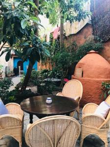 a table and chairs in a patio with a tree at Dar Dadicilef in Chefchaouen